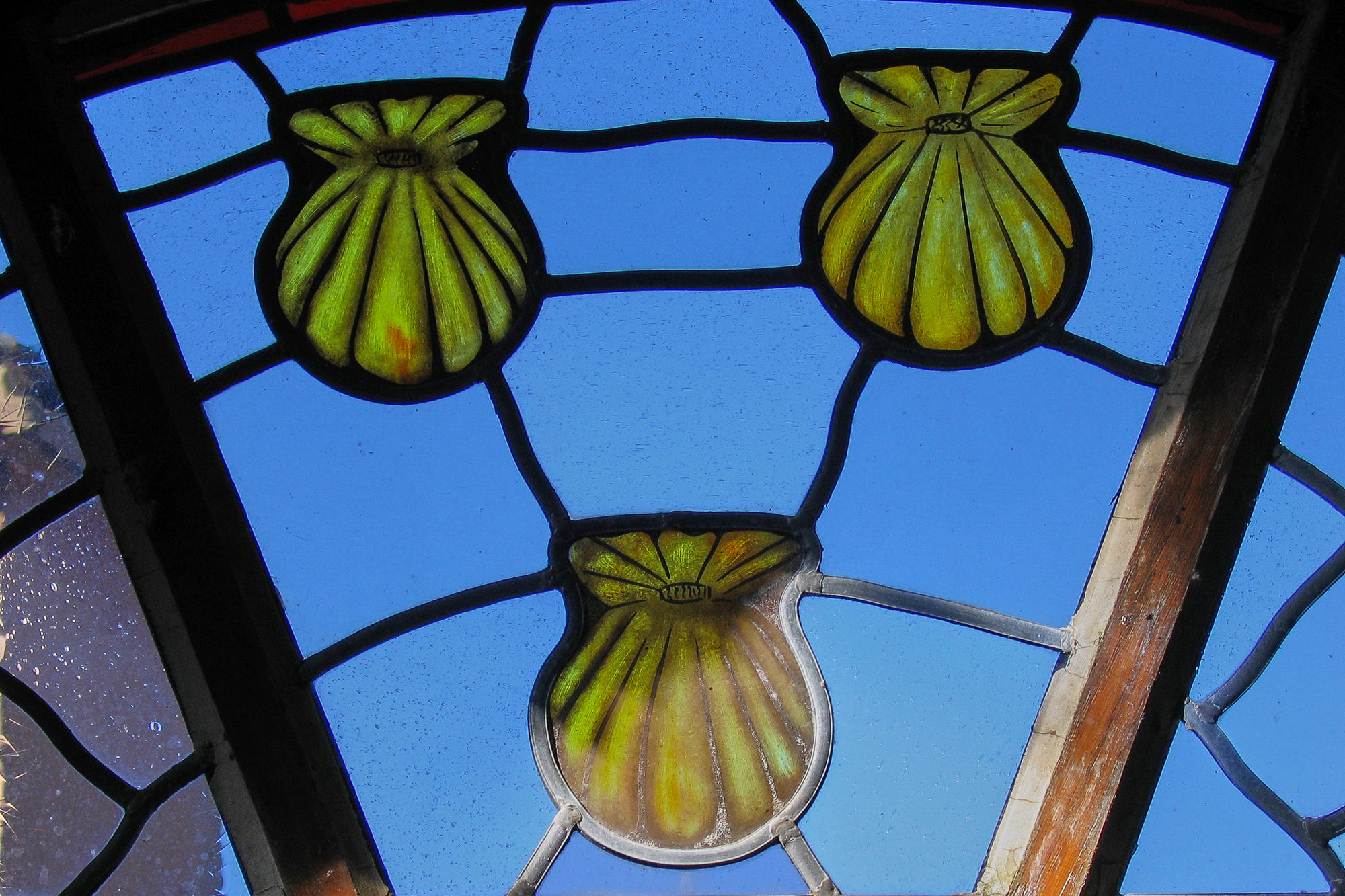 Tag 6: Von Espeyrac nach Conques, Fenster mit Jakobsmuscheln, dem Symbol des Jakobswegs